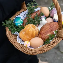 Wielkanocny koszyczek z jajkami, babką, kiełbasą i wędliną.