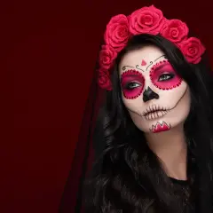 Kobieta z makijażem sugar skull, ozdobiona różami i welonem. Przerażające makijaże na Halloween w pełnej krasie.