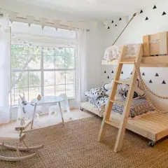Charming tween girl bedroom ideas: a bunk bed, rocking horse, and playful triangle wall decals create a fun, cozy space.