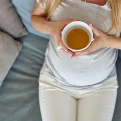 Kobieta w ciąży pije herbatę. Delikatny napój rozgrzewa i koi.