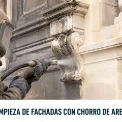 Trabajador con equipo de protección realiza limpieza de fachadas con chorro de arena, restaurando la piedra.