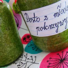 Dwa słoiki z zielonym pesto z pokrzywy, jedno z etykietą "Pesto z młodej pokrzywy".