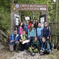 Gruppo di escursionisti posa davanti all'Orto Botanico delle Alpi Apuane. Un uomo tiene in mano una ciak.