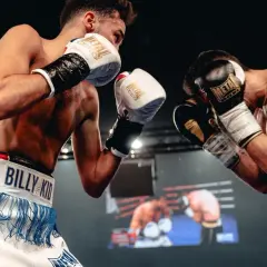 Two boxers face off, their gloves raised in a defensive stance. The hand placement shows readiness for a swift counter-attack.