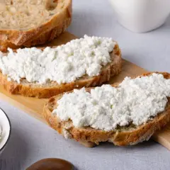 Fette di pane rustico con abbondante ricotta fresca. Un piatto semplice e gustoso, perfetto per una colazione o uno spuntino leggero.