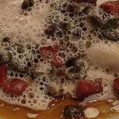 Kawałki mięsa i kaparów w pianie, jakby z eleganckiej restauracji w Danii stolicy.