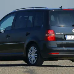 Ciemny Volkswagen Touran 2.0 TDI na drodze, widok z tyłu i boku.