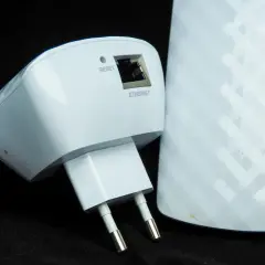Dwa białe urządzenia sieciowe: wzmacniacz Wi-Fi z wtyczką i portem Ethernet oraz większy repeater z oznaczeniami 5G, 2.4G i ikonami.