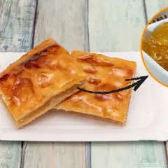 Dos trozos de pastel dorado con un relleno que parece pelo de ángel, servidos en un plato de papel.