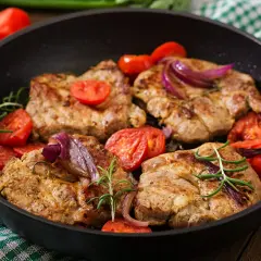 Soczysta karkówka z pomidorami i cebulą na patelni. Idealny pomysł, co zrobić z karkówki na obiad.