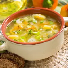 Aromatyczna, tradycyjna zupa jarzynowa z ziemniakami, marchewką i szczypiorkiem, podana z ciemnym chlebem.