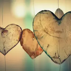 Holzherzen hängen an dünnen Fäden. Sie erinnern an die wahre agape bedeutung: bedingungslose Liebe, die wächst und Bestand hat.