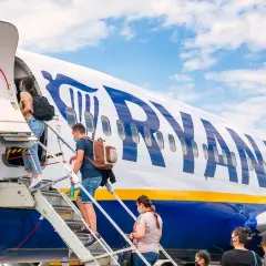 Pasażerowie wsiadają na pokład samolotu Ryanair. Czy Ryanair jest bezpieczny? Tysiące lotów dziennie świadczy o zaufaniu.