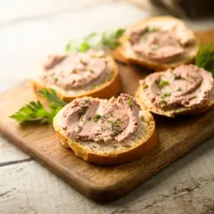Leberwurstbrote auf Holzbrett. Vorsicht bei Leberwurst in der Schwangerschaft wegen Vitamin-A-Überdosierung.