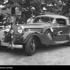 Elegancki, zabytkowy pierwszy mercedes z lat 30. XX wieku, z widoczną tablicą rejestracyjną IIA-42781, otoczony przez ludzi.