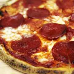 Pyszne, gorące ciasto na pizzę z serem i pikantnym pepperoni, idealne na wieczór filmowy.