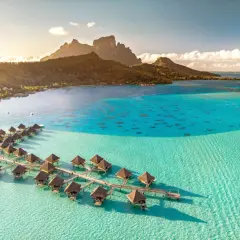 Bora Bora, gdzie jest? Rajskie bungalowy na wodzie w turkusowej lagunie, z górami w tle.