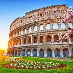 Colosseo illuminato dal sole, con fiori primaverili. Ideale per un soggiorno di costo metro Roma 2 giorni.