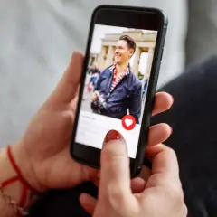 Kobieta przegląda profil mężczyzny na telefonie. Chce wiedzieć, co zrobić, żeby facet zatęsknił.
