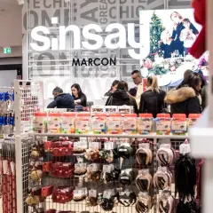 W sklepie Sinsay klienci wybierają akcesoria. W tle widoczny jest baner świąteczny. Dostępne są różne metody płatności.
