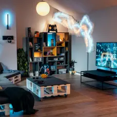 Gemütlicher hobbyraum einrichten mit Paletten-Sofa, Gaming-Regal, großer TV und stimmungsvoller Beleuchtung.