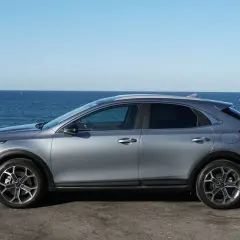 Un'auto grigia Euro 6 parcheggiata sul lungomare, con il mare blu e il cielo limpido sullo sfondo.