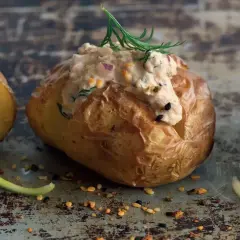 En gyllene bakad potatis med en krämig fyllning av tonfisk och örter, toppad med dill. En läcker och mättande rätt.