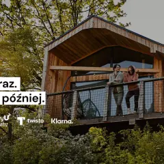 Para, klarna co to? Kup teraz, zapłać później. Dwie osoby na tarasie domku w drzewach.
