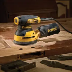 Szlifierka mimośrodowa DeWalt w akcji, pokazująca, jak działa, podczas renowacji drewnianych drzwi.