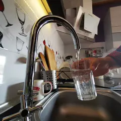 Nalewanie wody z kranu do szklanki. Woda ta może zawierać chlor, który jest często dodawany w celu dezynfekcji.