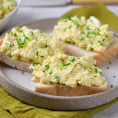 Pyszna pasta jajeczna jak dawniej, podana na kromkach chleba, posypana szczypiorkiem. Smak dzieciństwa na talerzu.