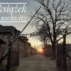 7 książek o Auschwitz. Brama z napisem "Arbeit Macht Frei" i budynki obozu.