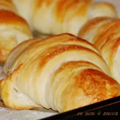 Cornetti con lievito madre dorati e fragranti, appena sfornati, pronti per una colazione perfetta.