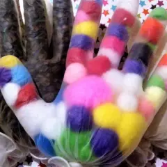 Kolorowe pompony w rękawiczkach to świetny pomysł, jak zrobić zabawki sensoryczne. W tle widać też inne wypełnienia.