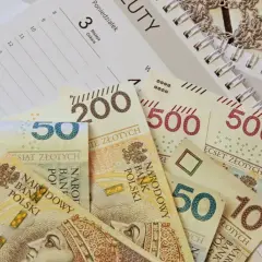 Polskie banknoty o nominałach 10, 50, 200 i 500 zł leżą na kalendarzu.