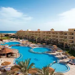 Relaks przy basenie w Amwaj Beach Club Resort. Palmy, leżaki i błękitna woda zapraszają do wypoczynku.