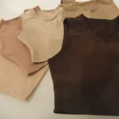 Kilka bezrękawnikowych bawełnianych t-shirtów w odcieniach beżu i brązu.