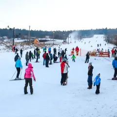 Stok narciarski w Bodzentynie tętni życiem. Widok z kamery online pokazuje narciarzy i snowboardzistów szusujących po ośnieżonych stokach.