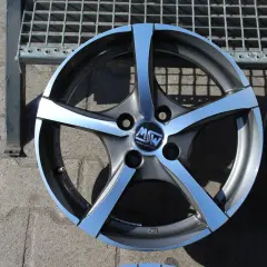 Szare felgi aluminiowe z polerowanymi ramionami i logo MW na tle kratownicy.