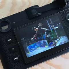 The Leica M11 displays a dynamic shot of a skateboarder mid-air at a graffiti-covered skatepark.