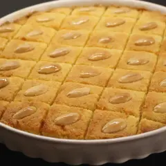 En gyllene basbousa, skuren i rutor och toppad med mandlar. Perfekt för ett enkelt basbousa recept.