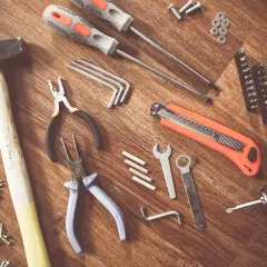 Un marteau, des tournevis, des pinces, une lame rétractable, des clés Allen et une perceuse : tous ces nom d'outils de bricolage sont prêts pour un projet.