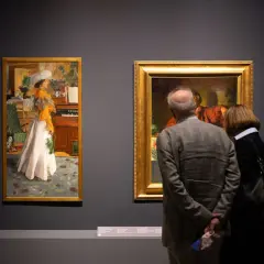 Para zwiedza muzeum sztuk użytkowych, podziwiając obrazy.