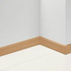 Angolo di una stanza con battiscopa in PVC effetto legno. Impara come tagliare battiscopa PVC per un'installazione perfetta.