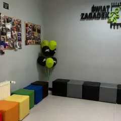 W poczekalni "Świat Zagadek" wiszą zdjęcia z przygód, balony i kolorowe pufy.