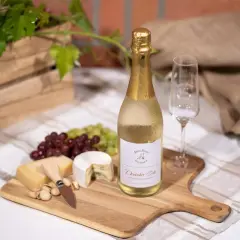 Niemieckie wino musujące "Deutscher Sekt" na desce z serami, winogronami i kieliszkiem. Idealne na letnie popołudnie.