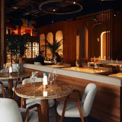 Arredare un locale con tavoli in marmo, sedie bianche e un'atmosfera calda. Un'elegante sala da pranzo con un tocco artistico.
