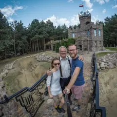 Rodzina pozuje do zdjęcia na tle kamiennego zamku, jednej z nietypowych atrakcji Podlasia.