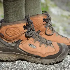Brown leather hiking boots with green socks. They fit snugly, offering support for any trail.