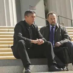 John Reese och Harold Finch från rollistan i Person of Interest sitter på trappsteg.